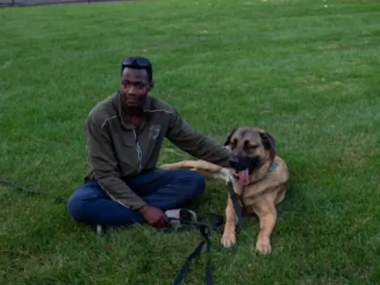 Mo sitting with German Shepherd, professional dog trainer Rochester NY